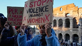 Une femme tient une banderole sur laquelle on peut lire "Stop à la violence contre les femmes" lors d'une manifestation organisée à l'occasion de la Journée internationale pour l'élimination de la violence à l'égard des femmes, à Rome.