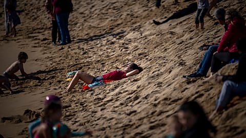 A woman sunbathes at a beach in Barcelona, Spain, Sunday, Feb. 4, 2024. Spain's weather agency says it experienced abnormally high temperatures for this time of year.
