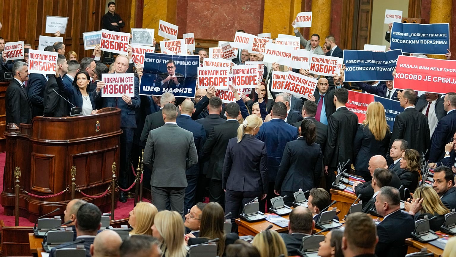 Opposition lawmakers hold banners reading: "Stole the elections" during a Serbia's parliament constitutive session in Belgrade, Serbia, Tuesday, Feb. 6, 2024