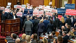 Opposition lawmakers hold banners reading: "Stole the elections" during a Serbia's parliament constitutive session in Belgrade, Serbia, Tuesday, Feb. 6, 2024