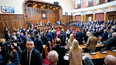Imagen en la que se puede ver a un grupo de legisladores de pie, para escuchar el himno nacional de Serbia, antes de una sesión constitutiva del Parlamento serbio.