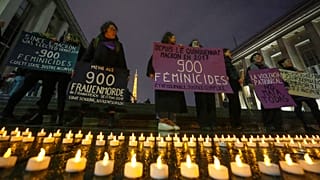Members of the women #NousToutes group hold placards that read, "since E. Macron was elected in May 2017, plus 900 feminicides, state and justice are guilty" in Paris, Feb 8