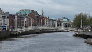 The River Liffey flows past the Ha'penny Bridge in Dublin, Ireland