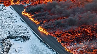 A view of lava crossing the main road to Grindavík and flowing on the road leading to the Blue Lagoon, in Grindavík, Iceland, Thursday, 8 Feb. 2024.