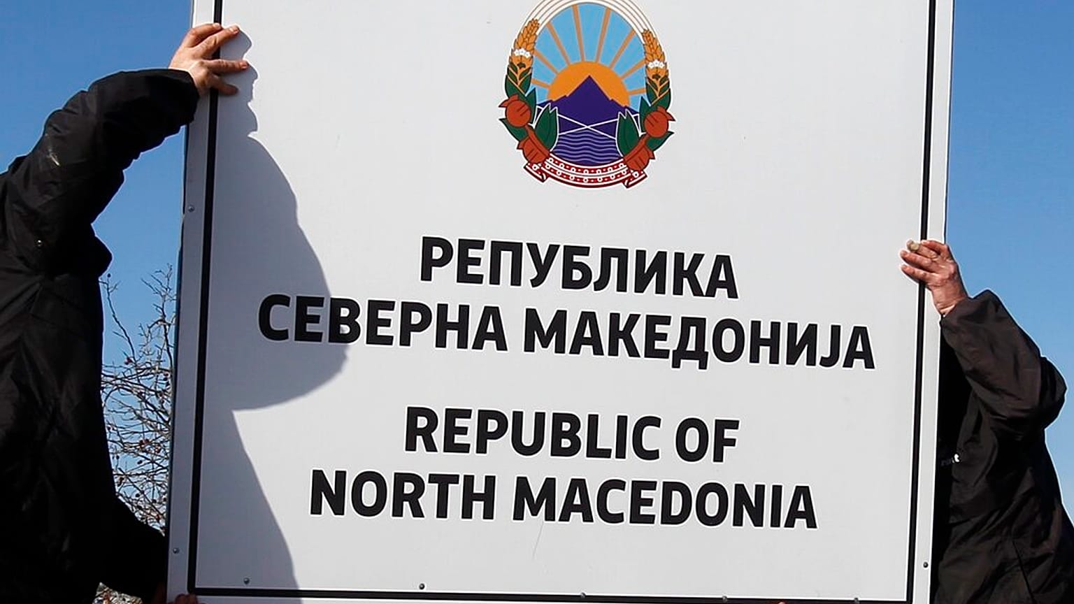 Workers install a new road sign with the name Republic of North Macedonia in the southern border with Greece, near Gevgelija, Wednesday, Feb. 13, 2019.