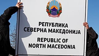 Workers install a new road sign with the name Republic of North Macedonia in the southern border with Greece, near Gevgelija, Wednesday, Feb. 13, 2019.