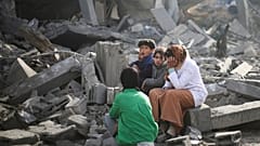 Palestinians sit by the destruction from the Israeli bombardment of the Gaza Strip in Rafah on Monday, Feb. 12, 2024. 