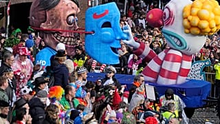 Un carro di carnevale raffigura un pagliaccio che smaschera Adolf Hitler come politico dell'Afd durante la tradizionale sfilata di carnevale a Dusseldorf, 12 febbraio 2024