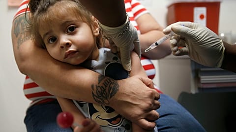 In a Friday, March 8, 2019 photo, Karma Islas, 2, is held by her mother Maria Islas of Dallas as she gets a shot for a vaccine administered by Demetria McRuffin, RN.