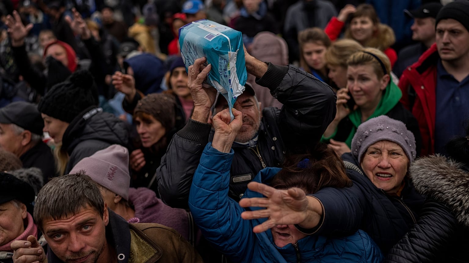 Des habitants se rassemblent à un point de distribution d'aide pour recevoir des fournitures dans le centre-ville de Kherson, dans le sud de l'Ukraine.