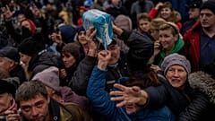 Anwohner versammeln sich an einem Verteilungspunkt für Hilfsgüter in der Innenstadt von Cherson in der Südukraine und erhalten Hilfsgüter.