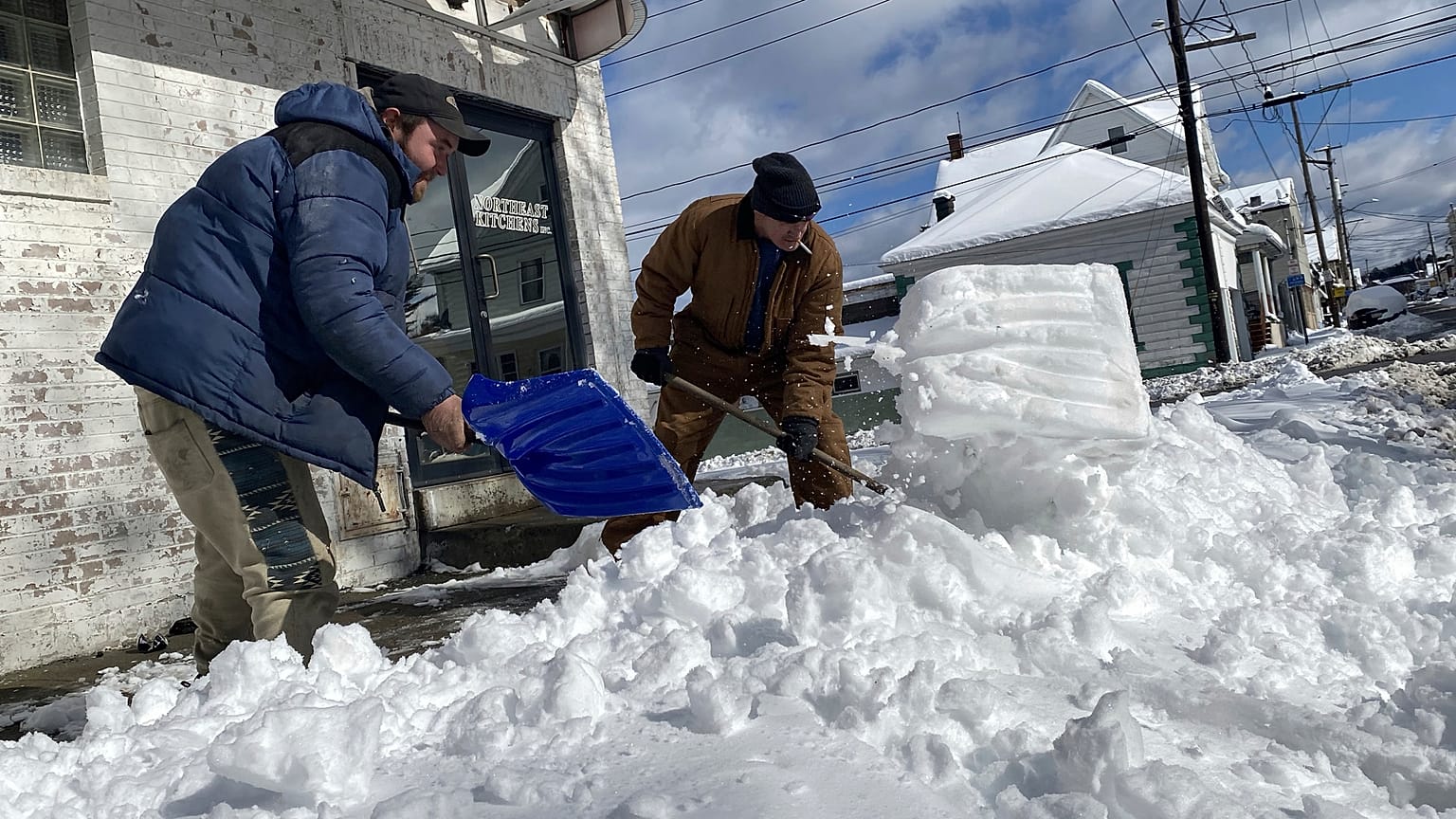 Unos hombres apartan nieve de la calle.