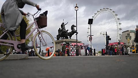 A woman rides a bike in London, Thursday, Nov. 17, 2022. 