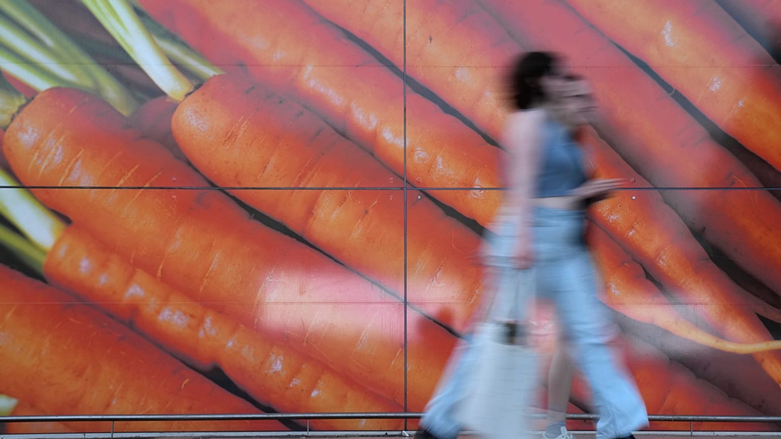 Shoppers walk past a large poster outside a supermarket in London, on June 10, 2023.