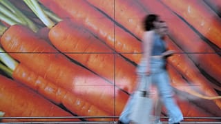 Αγοραστές περπατούν μπροστά από μια μεγάλη αφίσα έξω από ένα σούπερ μάρκετ στο Λονδίνο, στις 10 Ιουνίου 2023.