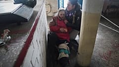 Женщина оказывает первую помощь раненой после обстрела российской артиллерией города Вовчанск, Харьковская область, Украина, в пяти километрах от российской границы, 13.02.24
