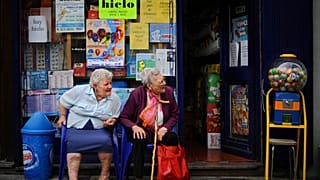 Two elderly women enjoy the day while they rest outside a shop, in Pamplona, northern Spain on Monday, June 17, 2013.