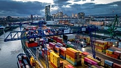 A container is loaded onto a cargo ship in the harbor in Frankfurt, Germany, Wednesday, Dec. 13, 2023. In background the European Central Bank. (AP Photo/Michael Probst)