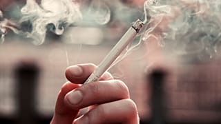Uma pessoa segura um cigarro.