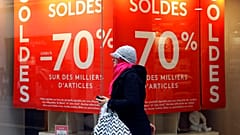 A woman walks past a store advertising for winter sales in Marseille, southern France, Thursday, Jan. 7, 2016
