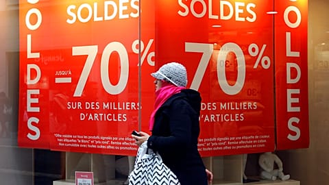 A woman walks past a store advertising for winter sales in Marseille, southern France, Thursday, Jan. 7, 2016