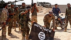 قوات الأمن العراقية تحمل علم تنظيم الدولة الإسلامية الذي استولت عليه خلال عملية خارج آمرلي