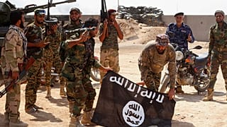 قوات الأمن العراقية تحمل علم تنظيم الدولة الإسلامية الذي استولت عليه خلال عملية خارج آمرلي