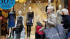 Shoppers walk by a shop in central London, Thursday, Nov. 17, 2011. 
