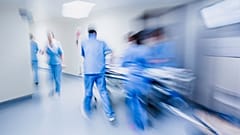Doctors and nurses pulling hospital trolley