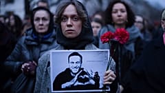 Eine Frau mit Blumen und einem Porträt des Kremlkritikers Alexei Nawalny während einer Protestaktion vor der russischen Botschaft in Berlin, 16. Februar 2024