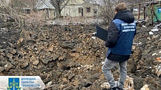 In this photo provided by the Donetsk Regional Prosecutor's Office, a war crime prosecutor inspects the scene after shelling in Pokrovsk, Ukraine, Thursday, Nov. 30, 2023.