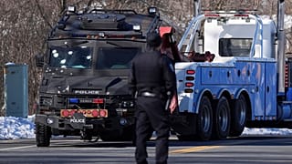 سحب سيارة شرطة عليها آثار رصاص بالقرب من مكان الحادث