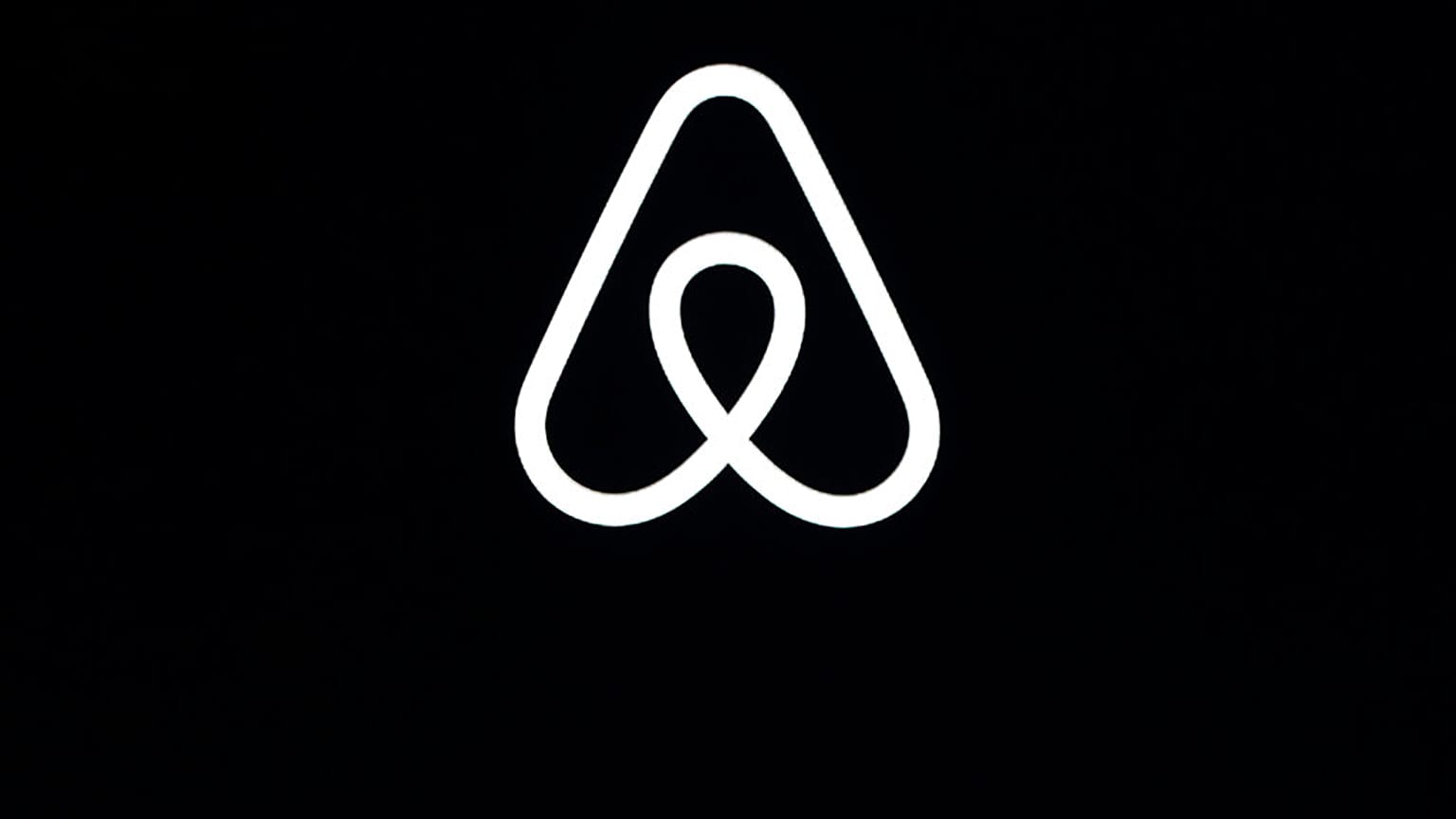 This Feb. 22, 2018, file photo shows an Airbnb logo during an event in San Francisco. 