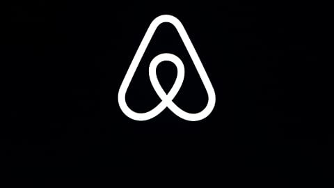 This Feb. 22, 2018, file photo shows an Airbnb logo during an event in San Francisco. 