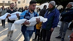 فلسطينيون بالقرب من مستشفى الأقصى يحملون جثامين أطفال قتلوا في قصف إسرائيلي في قطاع غزة