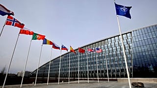 Bandiere dei Paesi che fanno parte dell'Alleanza atlantica davanti all'ingresso della sede Nato a Bruxelles 
