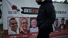 A man in Jerusalem walks past a banner with photographs of hostages who were abducted during Hamas's 7 October attack on southern Israel.