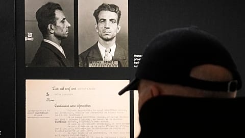 A visitor watches the Nov.18, 1943 police mugshot of Missak Manouchian, exhibited at the Shoah memorial, Tuesday, Feb. 20, 2024 in Paris.