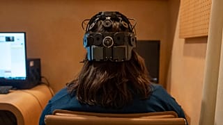 Emily Hollenbeck, a deep brain stimulation therapy patient, demonstrates an EEG device that records brain activity.