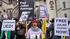 Demonstranten halten Transparente vor den Royal Courts of Justice in London, Dienstag, 20. Februar 2024. 