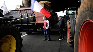 Farmers walk on a blocked highway, Wednesday, 31 January, 2024 in Chilly-Mazarin, south of Paris. 