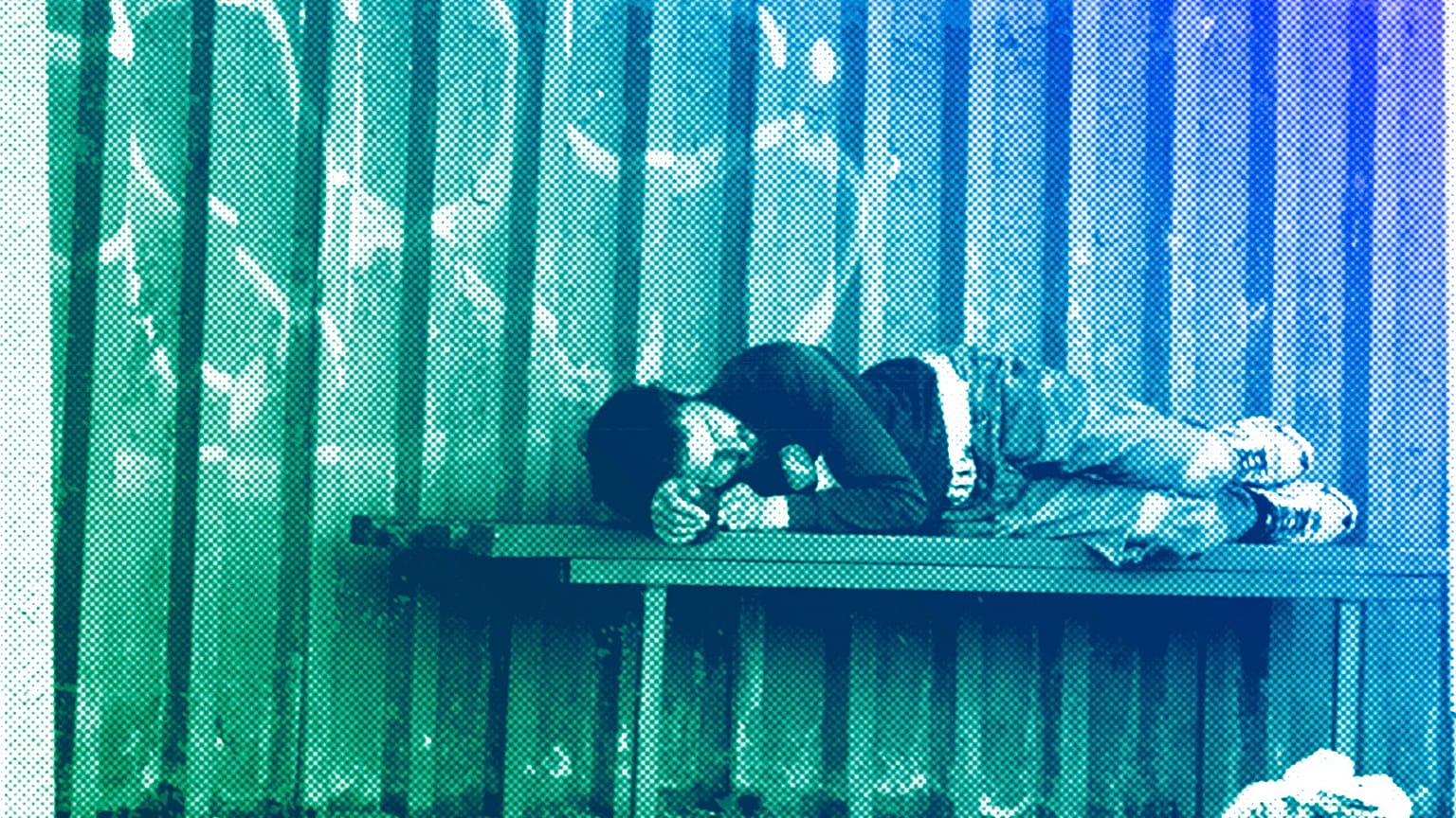 A homeless man sleeps on a bench at a bus stop on the outskirts of Kyiv, June 2022