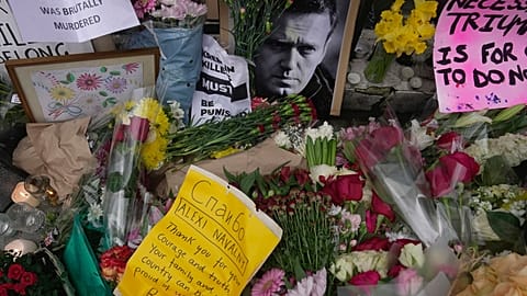 Flowers and portraits are left opposite the Russian embassy, to commemorate the death of Alexei Navalny in London, Monday, Feb. 19, 2024.