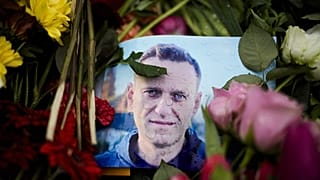 Rain drops cover a portrait of Russian opposition leader Alexei Navalny, placing between flowers in front of the Russian embassy in Berlin, Feb. 21, 2024. 