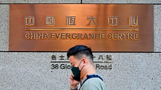 A man walks past the entrance of the headquarters of China Evergrande Group in Hong Kong Monday, Oct. 4, 2021. 
