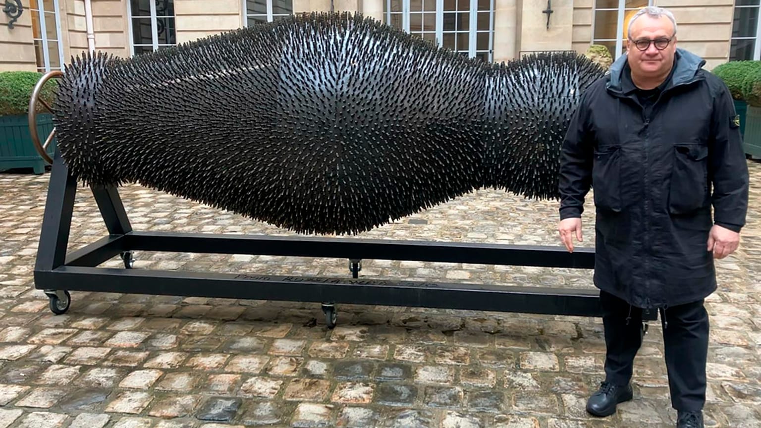 Ukraine's Mikhail Reva poses next to one of his art pieces, 22 February 2024, in Paris.