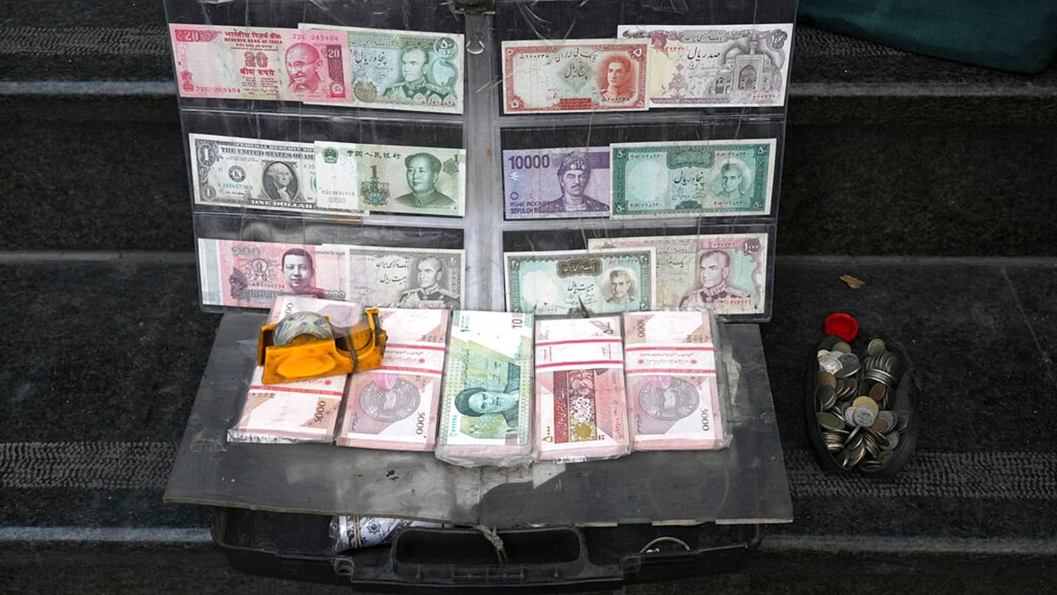 Current and pre-revolution Iranian banknotes and foreign currencies are displayed by a vendor at a commercial district in downtown Tehran, Iran, Friday, Dec. 23, 2022.