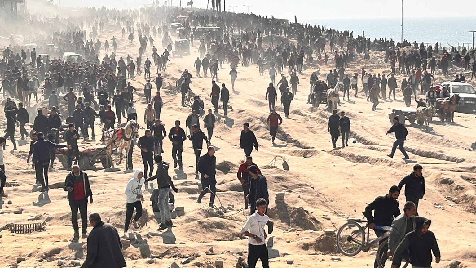 Palestinianos esperam ajuda humanitária numa praia na cidade de Gaza