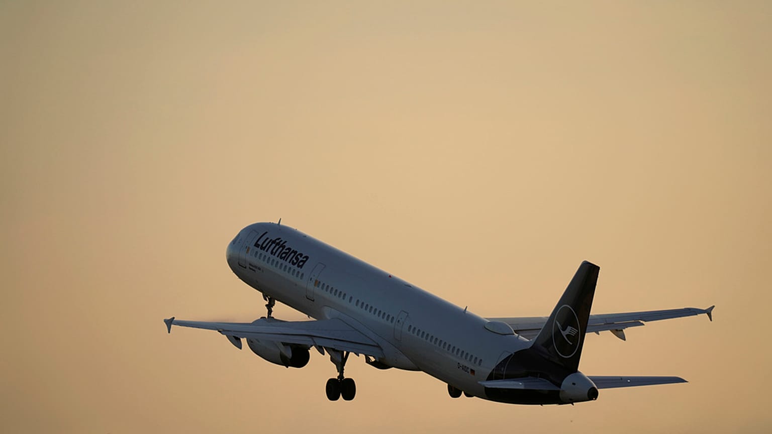 A Lufthansa Airbus A321 takes off from Lisbon at sunrise
