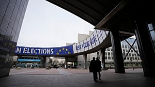 People walk under a banner advertising the European elections outside the European Parliament in Brussels, Wednesday, 24 January, 2024